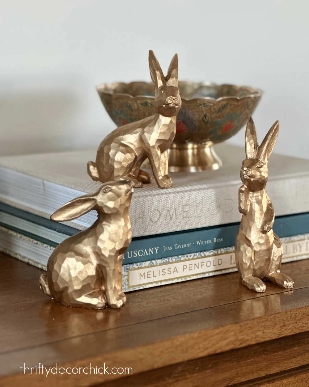 three gold bunnies on books
